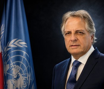 Manuel Rodríguez Cuadros junto a las banderas del Perú y de las Naciones Unidas